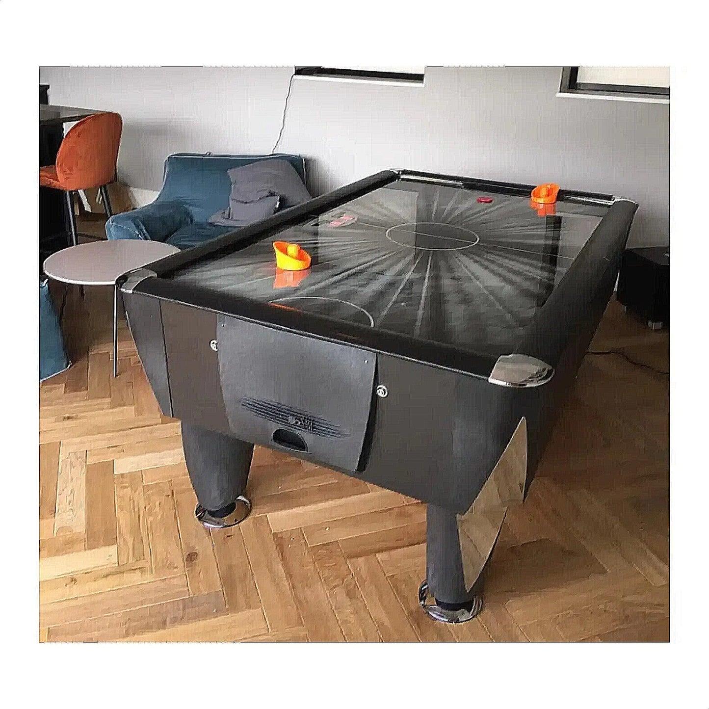 Air hockey table in a room with furniture and decor