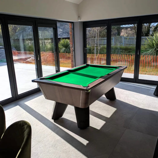 Pool table in a room with large windows showing an outdoor view.