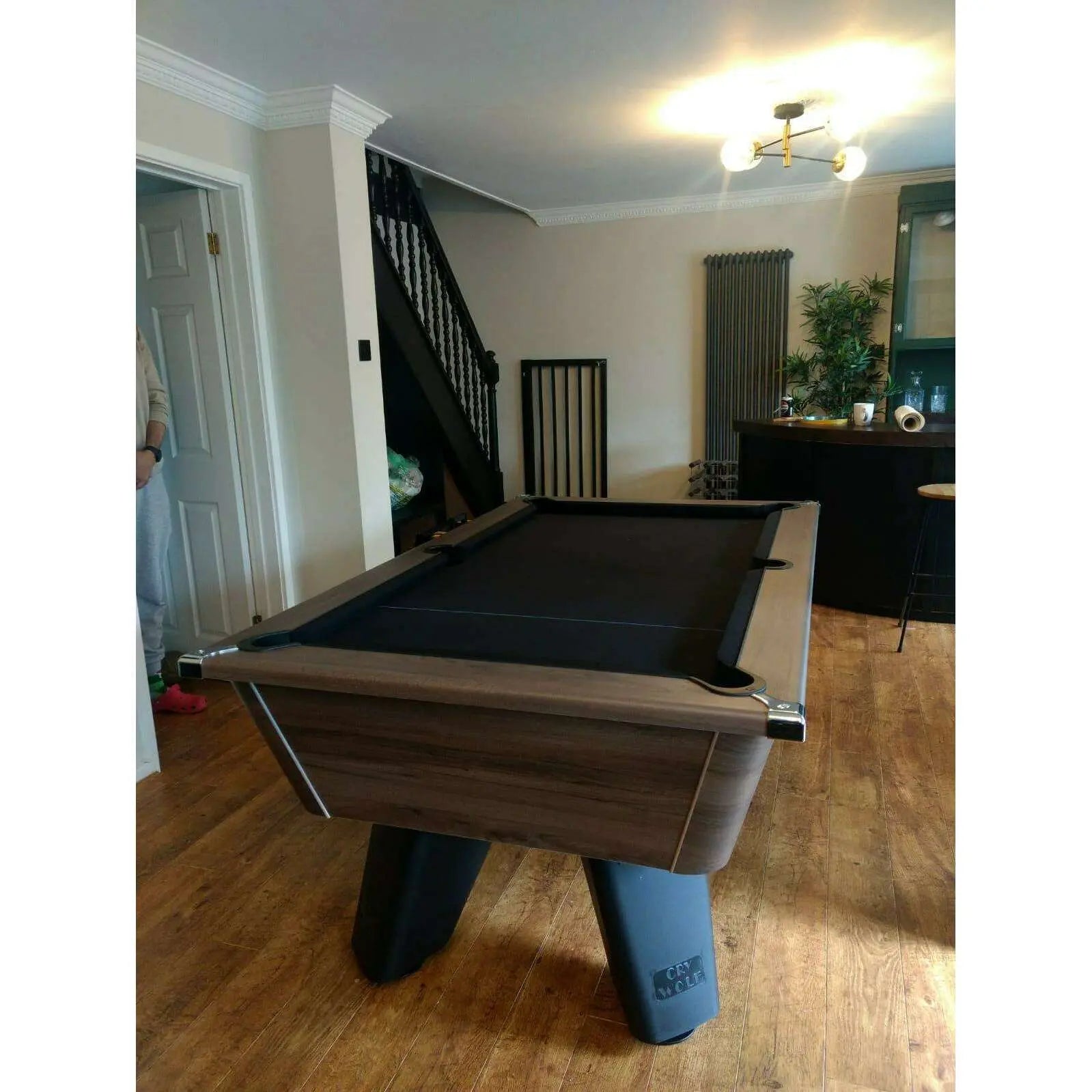 Pool table in a room with wooden floor and staircase
