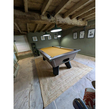 Pool table in a room with wooden beams and framed pictures on the wall.