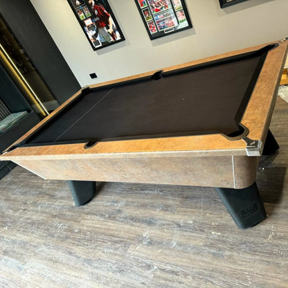 Pool table with a brown and black surface in a room with framed pictures on the wall.