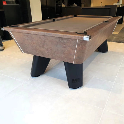Pool table with wooden finish and black legs on a tiled floor.