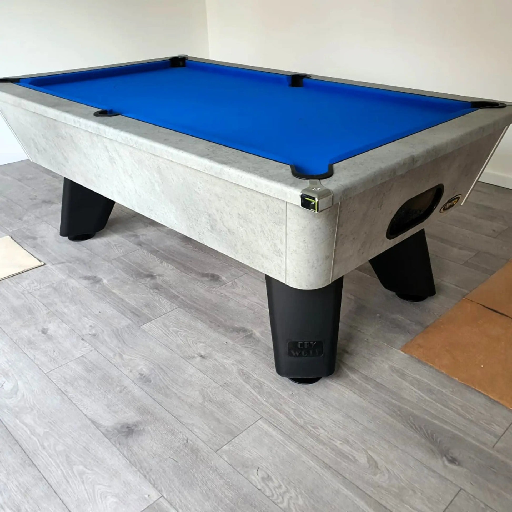 Pool table with blue felt surface on a wooden floor